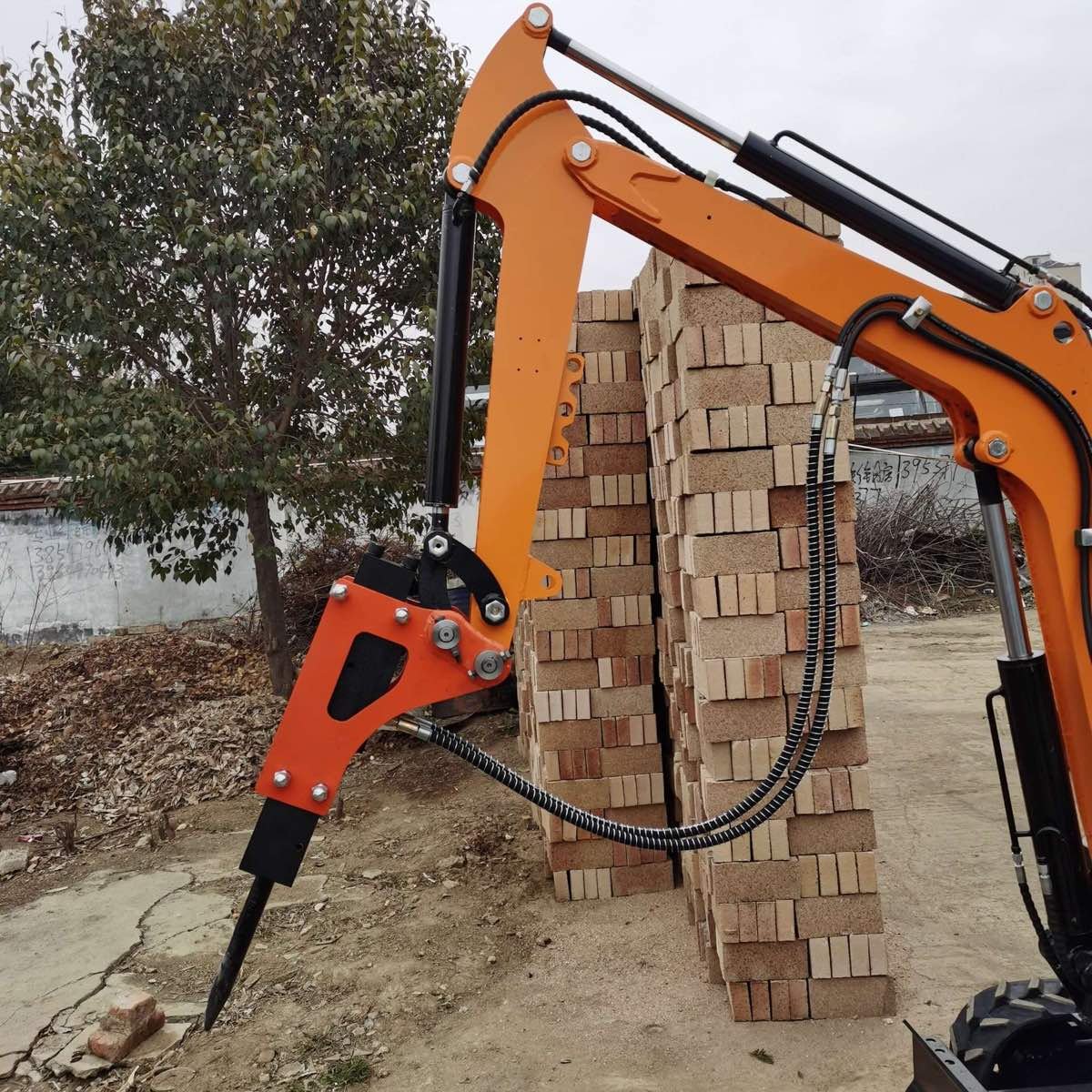 Hydraulic breaker attachment mounted on a compact excavator